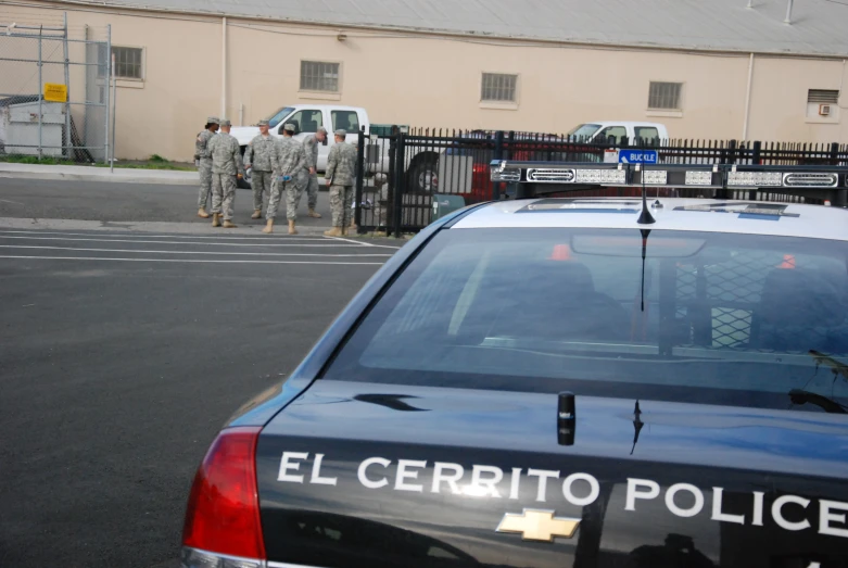 a group of people standing in front of a police car