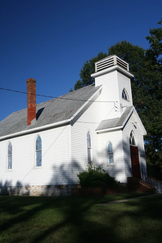 an old church that is painted white and has arched windows