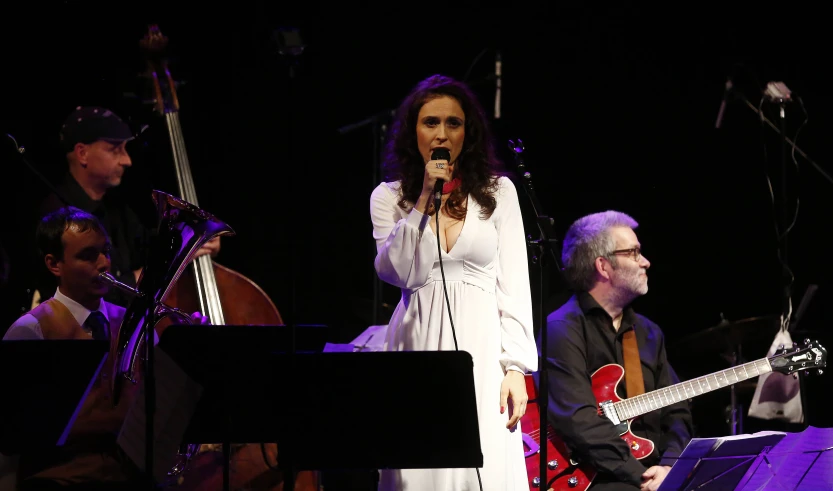 a woman is standing with a microphone in her hand