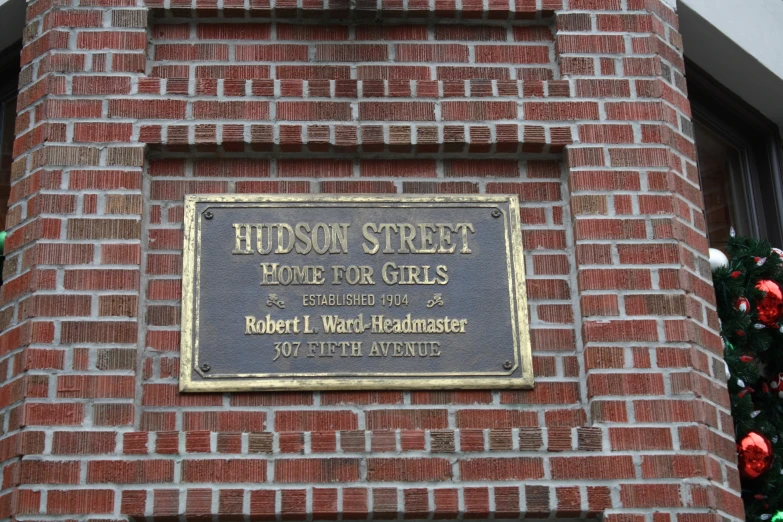 there is a plaque on a brick building