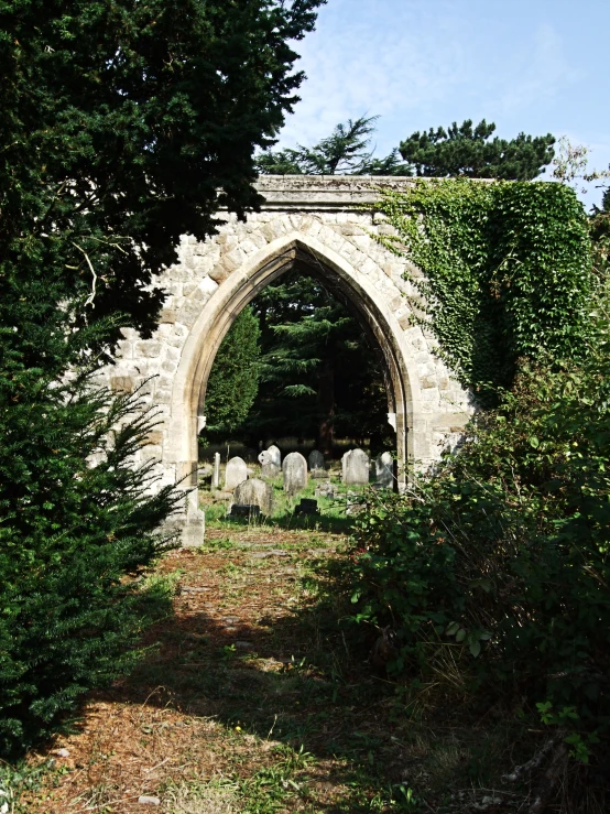 a stone arch with a cemetery in it