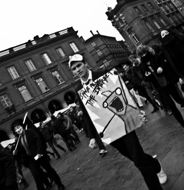 a person holding up a sign in front of a group of people