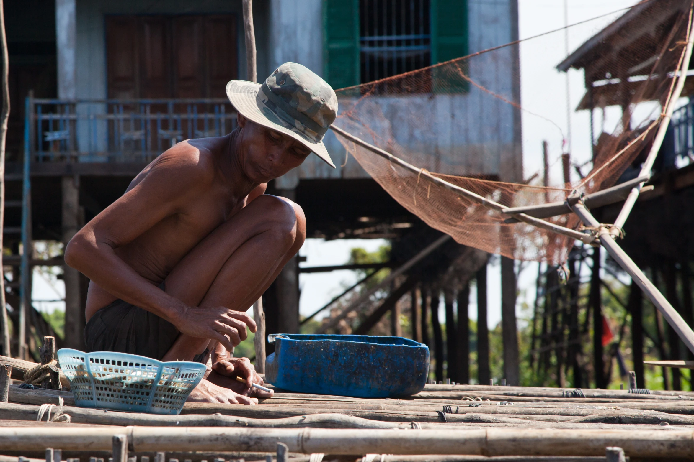 a man sitting on the ground in front of a house