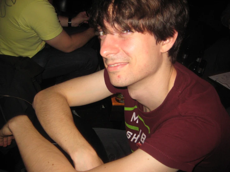 a young man smiles in the dark during a performance