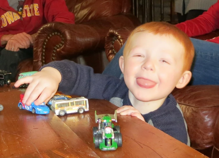 the boy has red hair, and is smiling at the camera