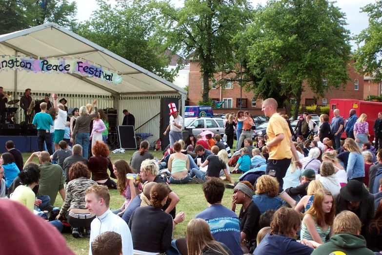 a large crowd is standing in front of tents