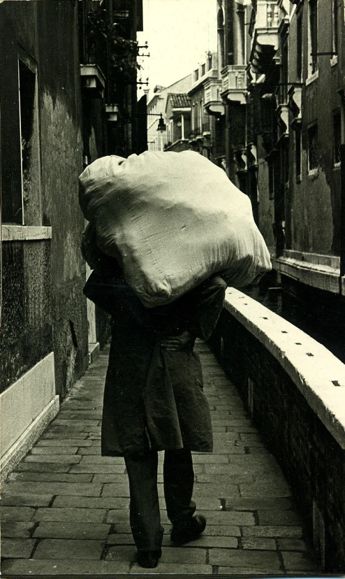 an old black and white po of a man carrying soing on his back