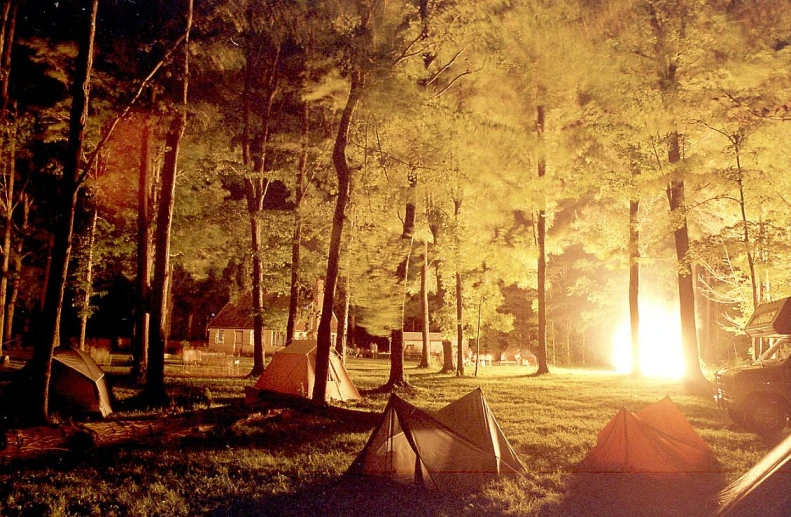 the camp ground is dimly lit and has several tents