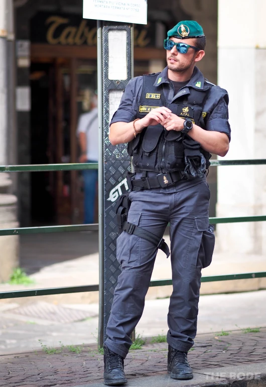 a policeman is standing near a pole