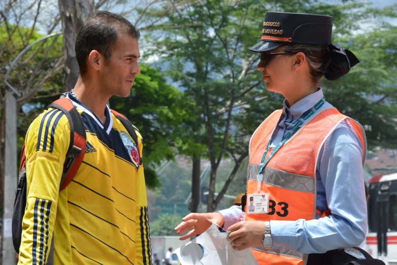 a woman talking to a man in front of a building