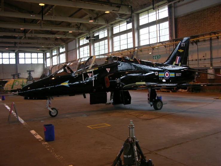 a couple of jet airplanes are parked in a hanger