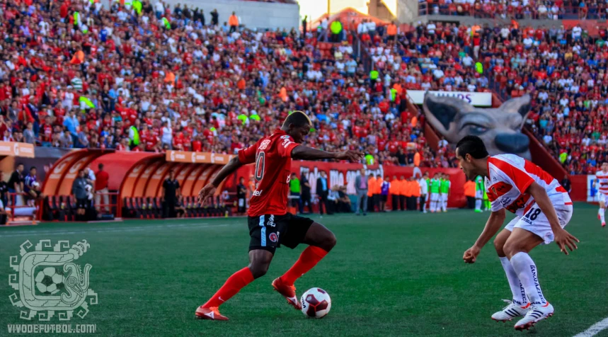 two young men compete for the soccer ball on the field