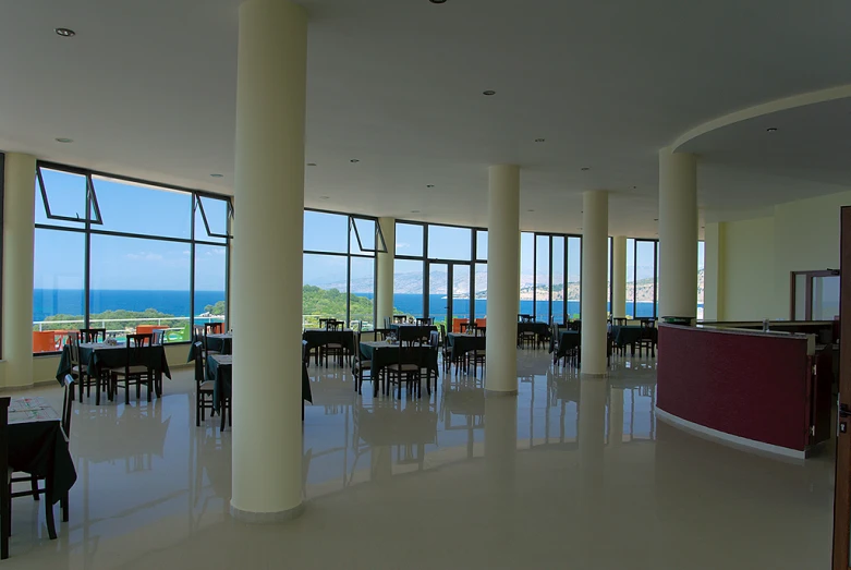 an empty dining area overlooking the ocean with chairs