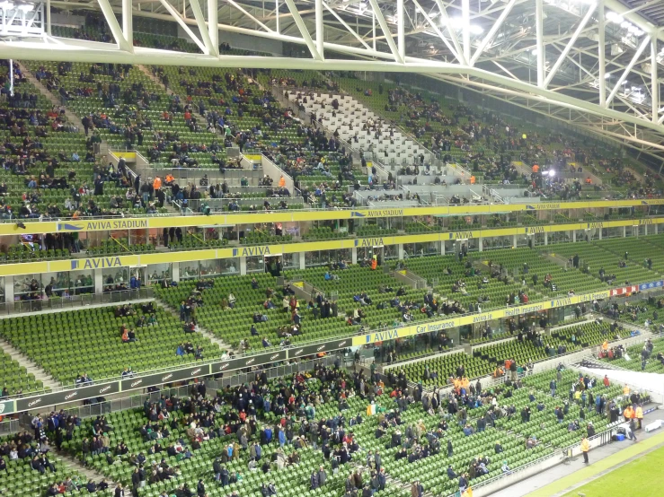 a large crowd is standing in an empty soccer field