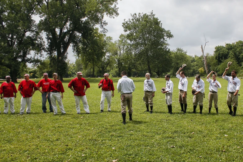 a group of boys stand in a park, all dressed in baseball uniforms