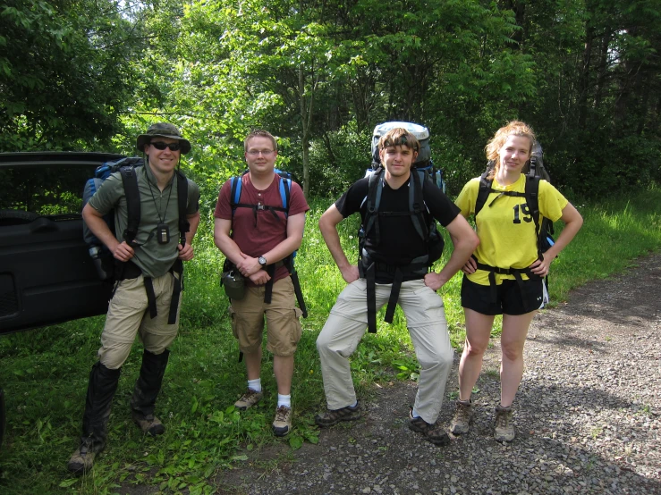 four people with backpacks posing for a picture