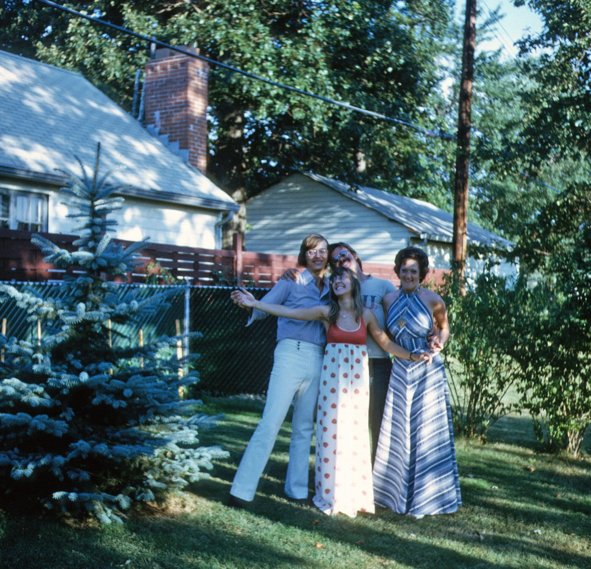 three people that are hugging each other in the grass