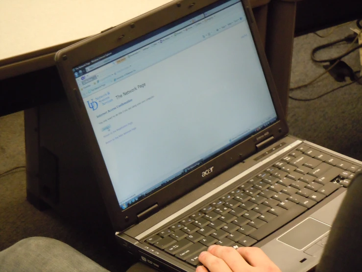 a person typing on a laptop computer while wearing a watch