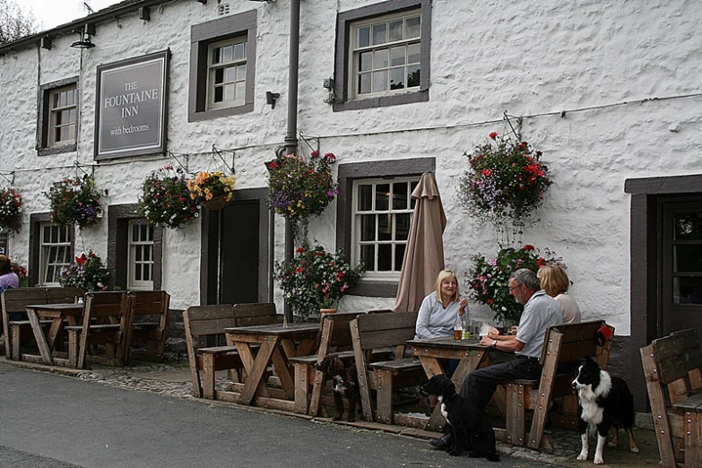 people sit on a bench in front of a building