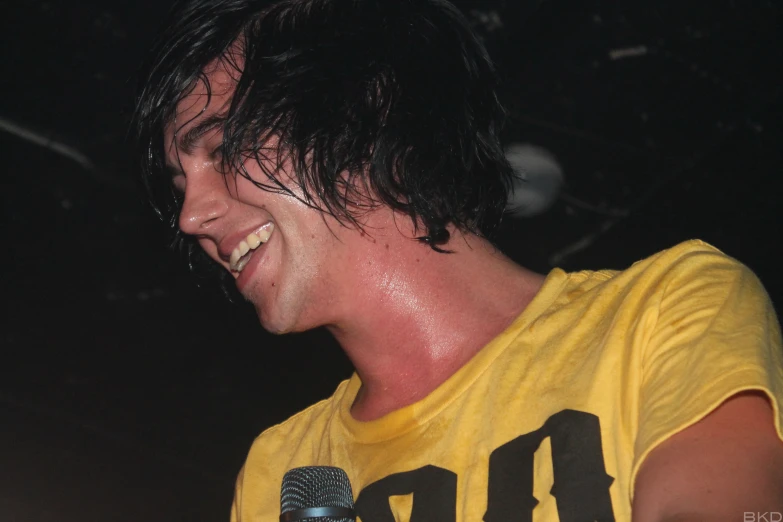a man wearing yellow shirt with a microphone