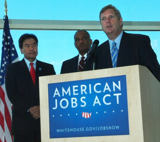 a group of men who are standing at a podium