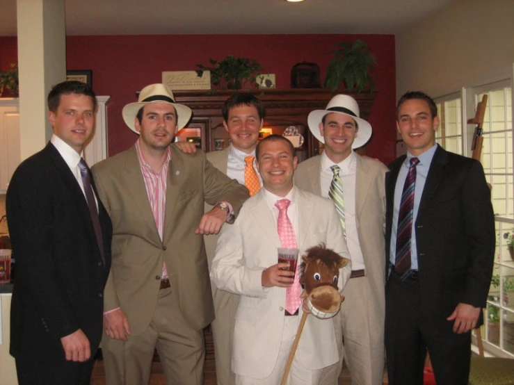 some men in fancy outfits stand together with their stuffed horse