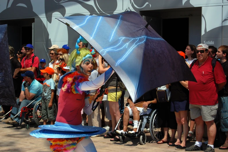 a woman in costume holding a large blue umbrella