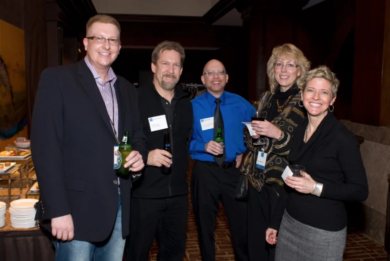 a group of four people are holding wine