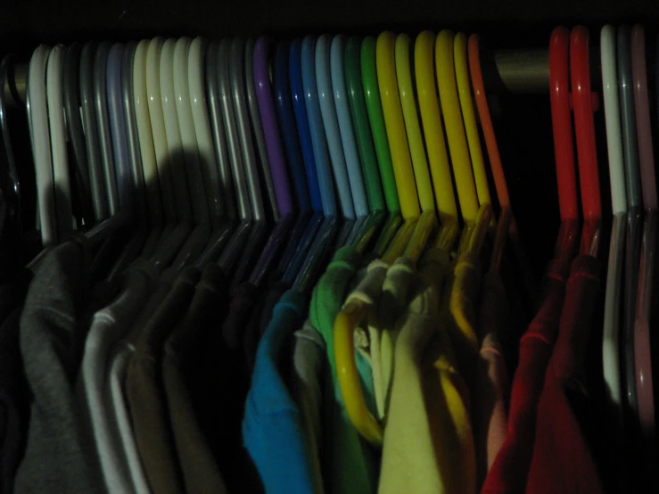 a rack full of colorful, striped and plain sweaters