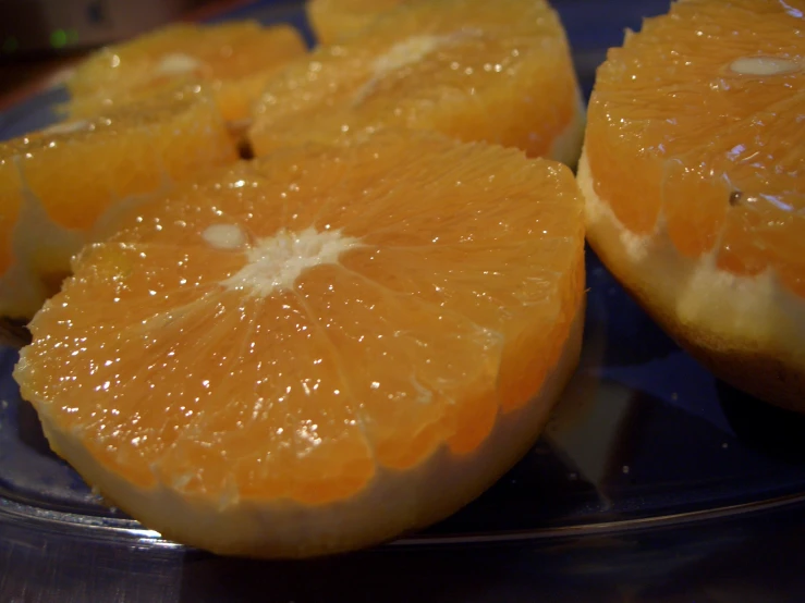 a glass plate topped with oranges cut in half