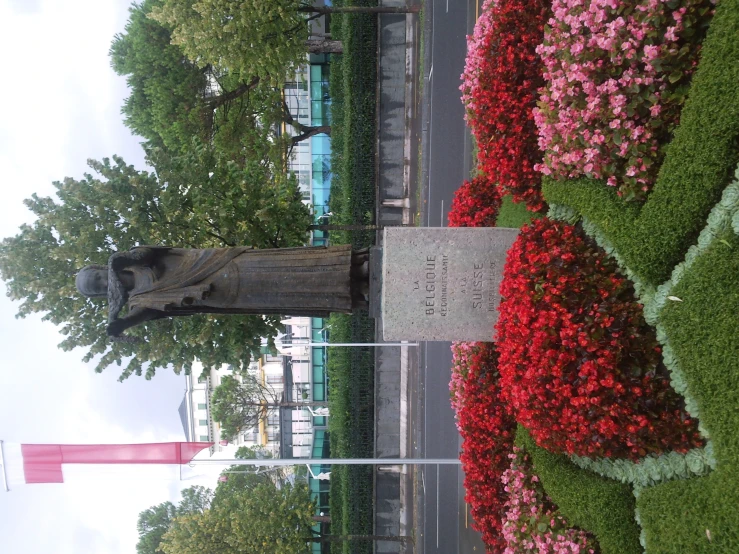 a wooden statue in front of a display of flowers