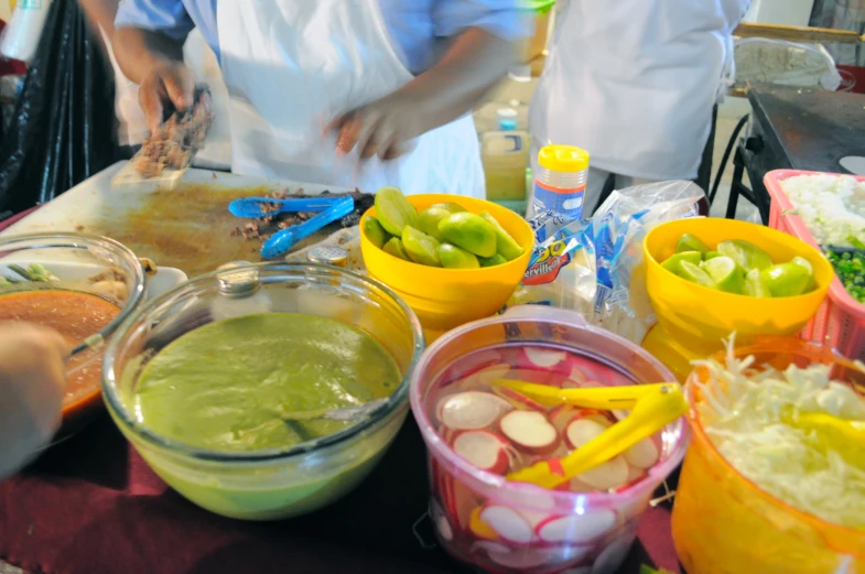 people in line preparing an individual's meal at a buffet