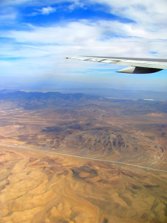 an airplane flies over the desert as it flies through the air