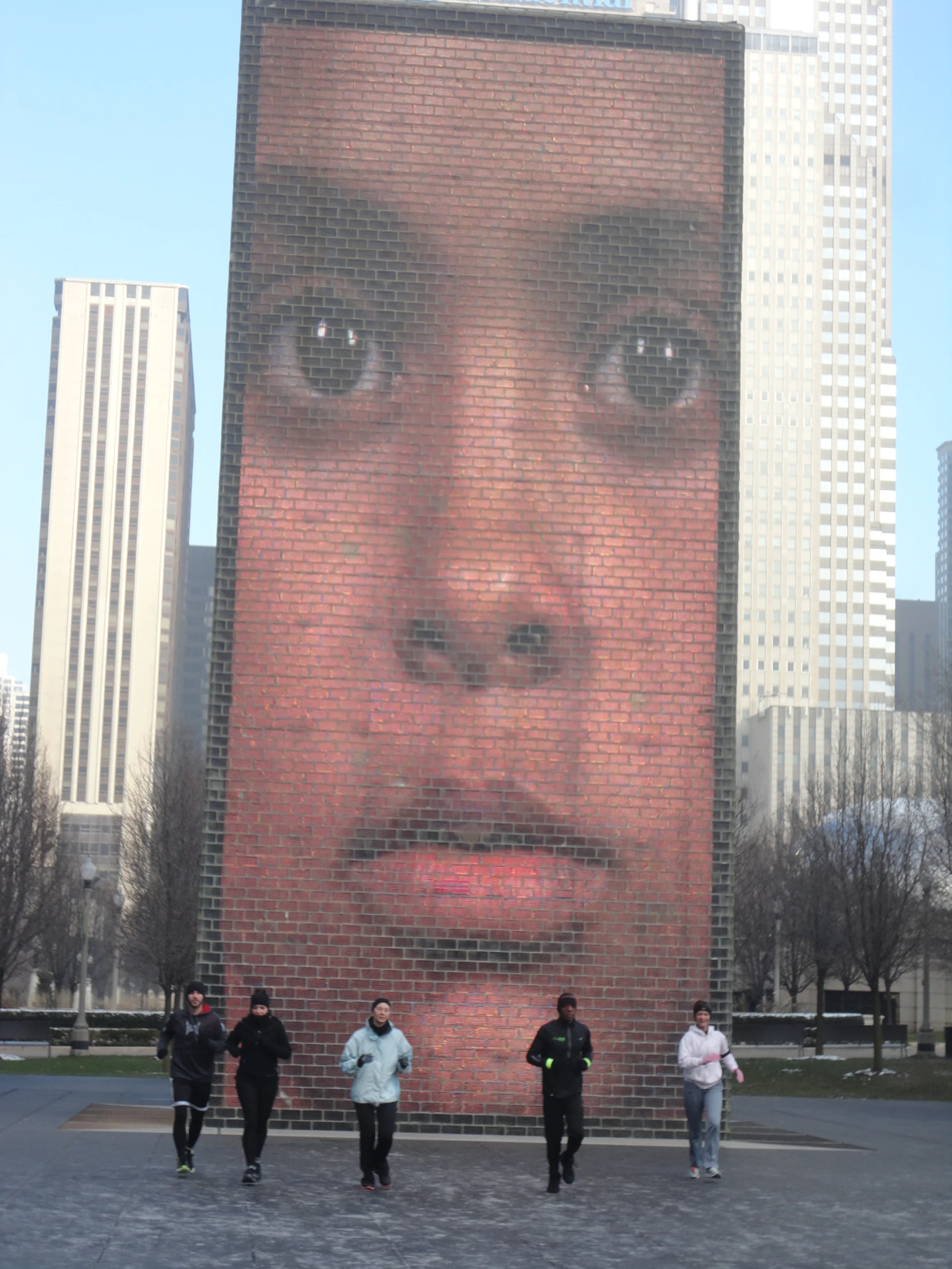 four people standing in front of a large advertit on a wall