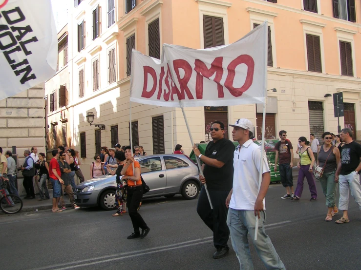 people are walking down the street with a sign