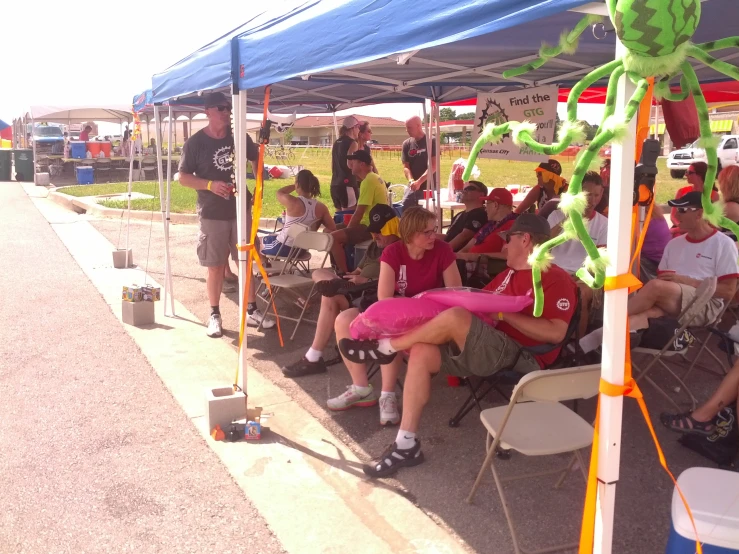 some people sitting under a canopy at a race