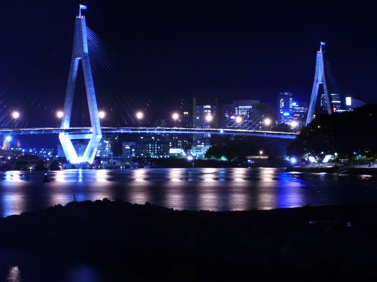 the bridge over the river has lights reflecting off the water