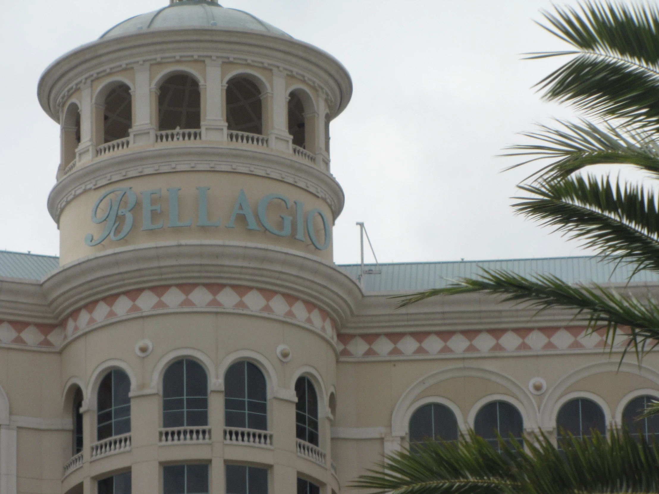 a large building that says belligo next to palm trees