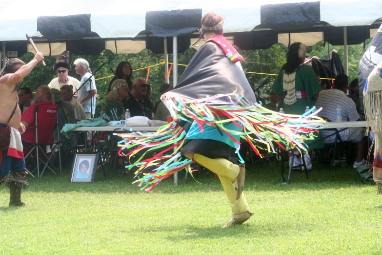 a woman in a costume dancing on a grass field