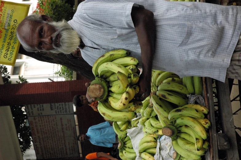 a man standing in front of a pile of bananas