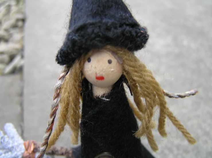 a doll is wearing a black hat