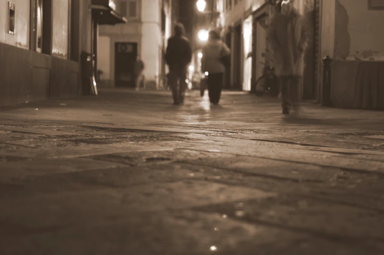 a city street is covered in light on a foggy evening