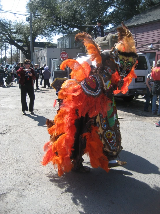 a person dressed in colorful costumes standing on the street