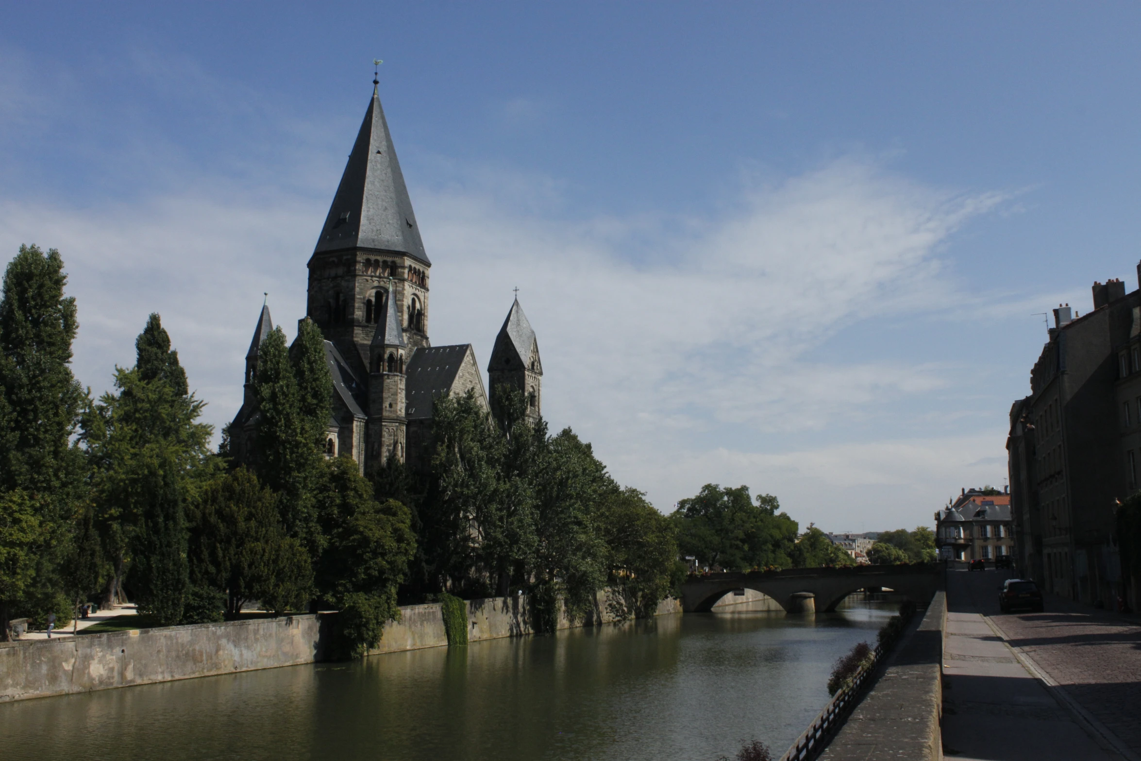 a large building with a clock on it standing next to a river