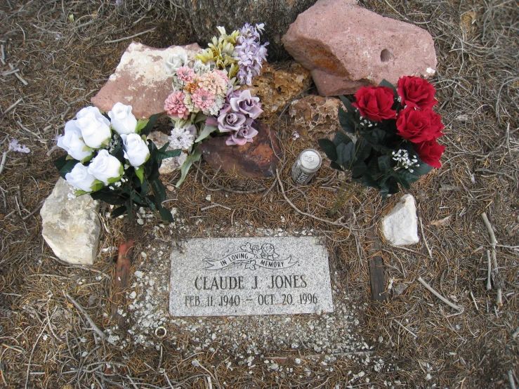 many colorful flowers are placed next to a grave