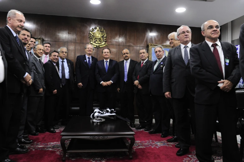 a group of men wearing suits are standing in a large room