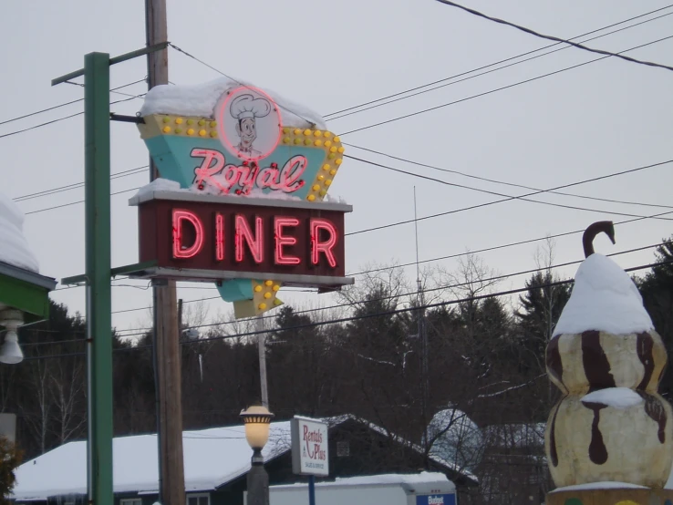 a neon sign sitting in the snow next to other holiday items