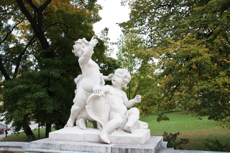 statues in front of trees with sky in background