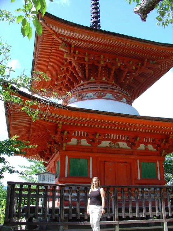 a woman is standing in front of a large building