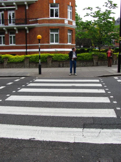 an intersection has an white crosswalk on the street
